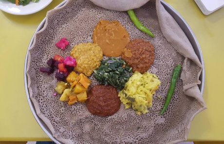 Injera on a platter with colorful stews and side dishes, African Big Tour