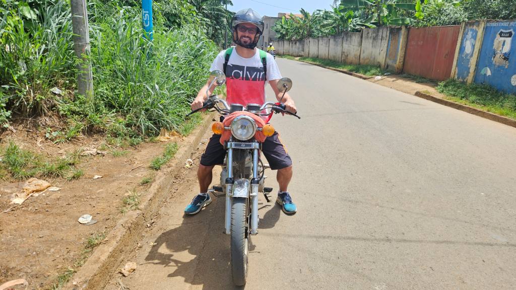 Rok rides a motorbike through the streets of São Tomé, São Tomé and Príncipe