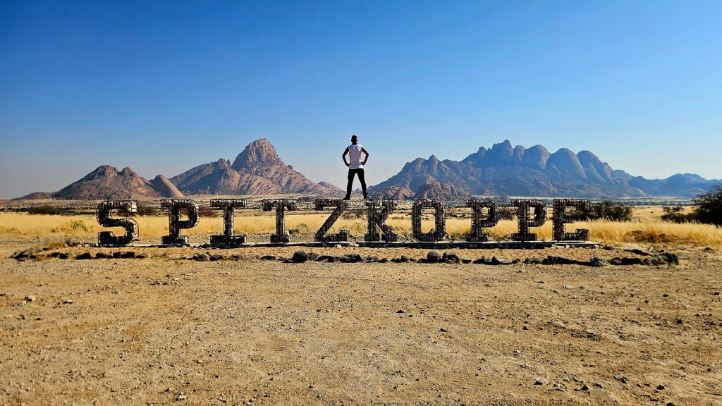 Namibia_Spitzkoppe_Rok Rok standing on top of the Spitzkoppe sign in Namib Desert, Namibia