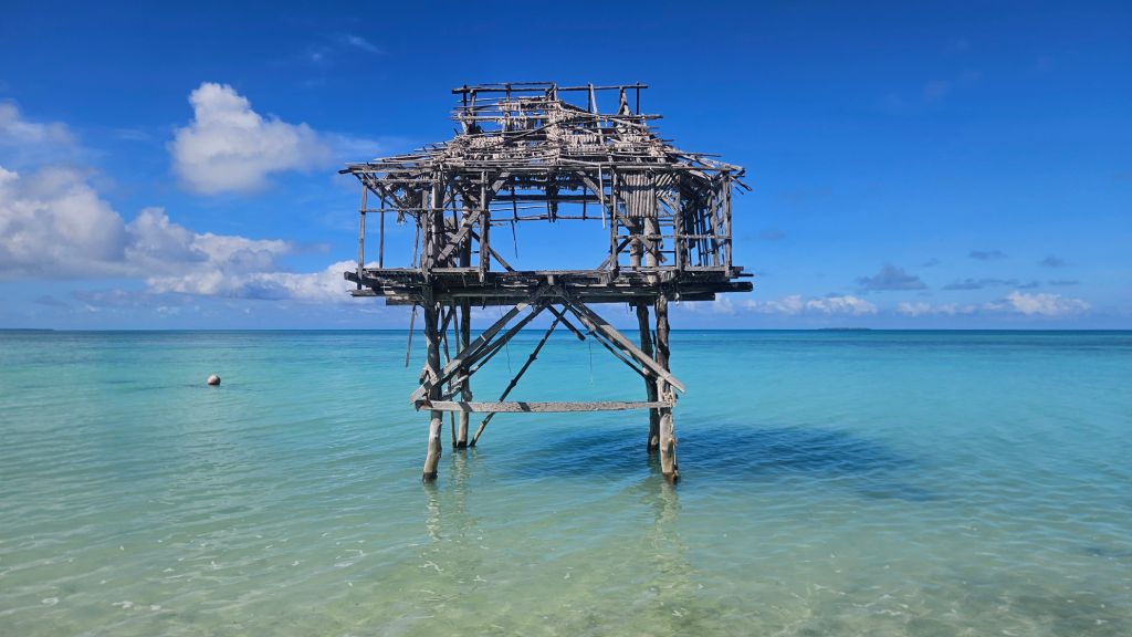 Wooden hut on stilts in the turquoise sea at Abaiang Island, Kiribati