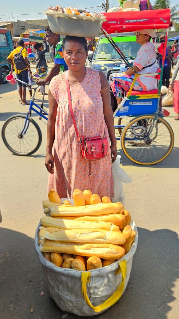 Malagasy bread vendor with baguettes in Moramanga, Madagascar